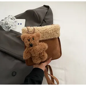Detail of faux shearling and suede shoulder bag with a 3D plush bear decoration