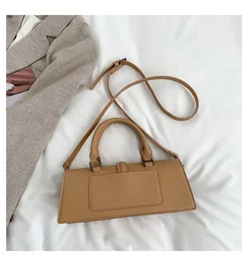 Detail der kamelfarbenen Lederhandtasche mit Schultergurt auf weißem Textilhintergrund