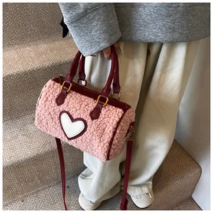 Detail van de roze teddy boston tas met rode leren hartpatch en gouden metalen accenten
