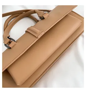 Detailaufnahme der hellbraunen Ledertextur und Nähte einer eleganten Handtasche