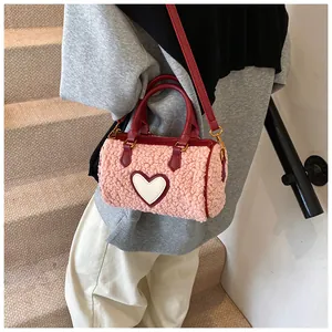 Detail van roze lamswollen Boston tas met wit hartje en rode leren handvatten voor dames
