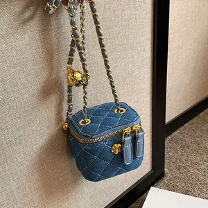 Blue denim mini vanity bag with quilted pattern, gold camellia charm and chain strap
