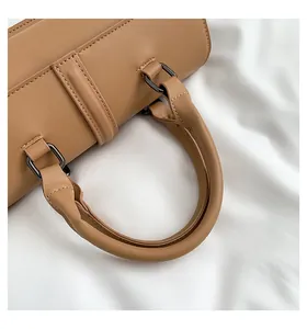 Detailansicht der hellbraunen Ledertasche mit feinen Nähten und dunklen Metallbeschlägen