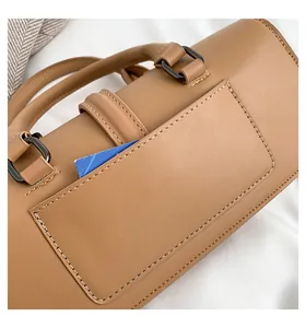 Detail einer braunen Ledertasche mit feinen Nähten, Metallring und funktionalem Kartenfach