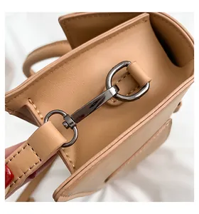 Nahaufnahme der apricotfarbenen Ledertasche mit grauer Metallschnalle und feinen Nähten