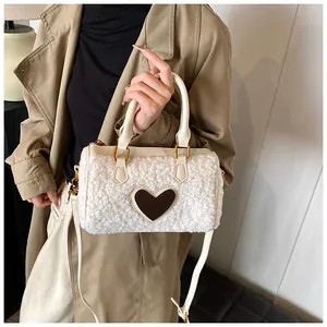 Detail van witte Boston-tas van lamswol met bruine hartpatch en lederen handvatten