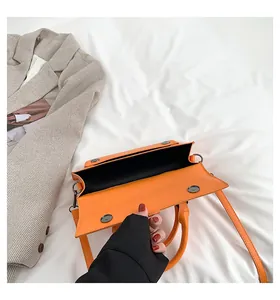 Detailansicht der orangefarbenen Tasche mit Magnetverschluss und schwarzem Innenfutter