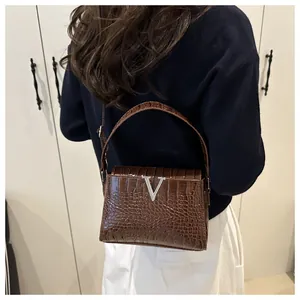 Brown crocodile embossed leather handbag with silver V-shaped metal buckle detail