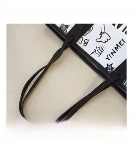 Macro shot of durable black leather handles and creative graffiti print on the tote bag