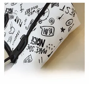 Close-up of white tote bag featuring street graffiti print and faux leather texture