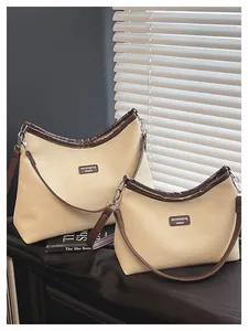 Details von zwei Canvas-Schultertaschen in verschiedenen Größen mit Lederbesatz