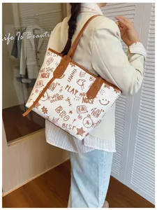 Large tote bag with brown bear graffiti print shown in a lifestyle shoulder carry shot