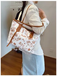 Detailed close-up of large tote bag featuring vintage brown graffiti prints and slim straps