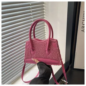 Dettaglio della mini borsa tote in peluche rosa acceso con texture agnellata e ecopelle