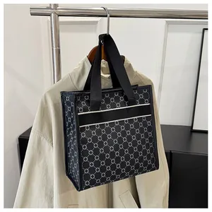 Detail view of printed tote bag featuring white geometric floral patterns on black fabric