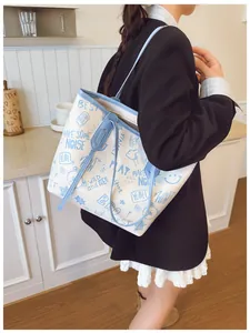 Detail of a white tote bag with blue straps and American graffiti-style cartoon prints