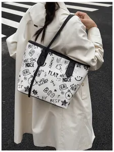 Street style large tote bag with black graffiti prints and black shoulder strap details