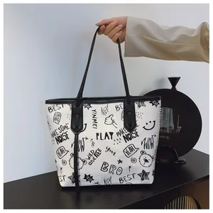 Close-up of graffiti art print on white large tote bag with black handles and metal hardware