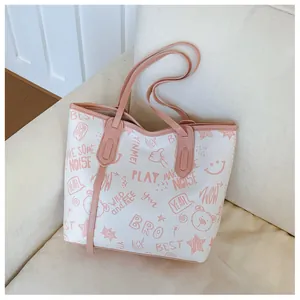 Detail of white tote bag featuring cute pink cartoon graffiti prints on cream sofa