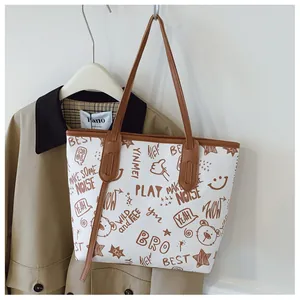 Close-up of large tote bag with cute cartoon bear prints on khaki trench coat background