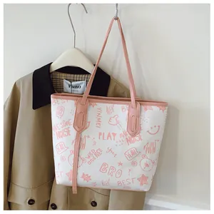 Detailed view of the large tote bag showing colorful cartoon graffiti prints and pink straps