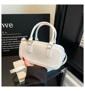 Detail of white glossy patent leather handbag with gold hardware and dual handles