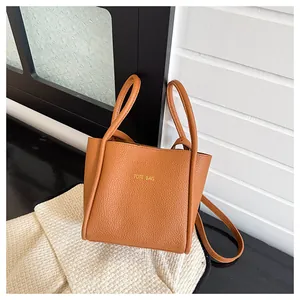 Detailansicht der karamellbraunen Leder-Tote-Bag mit Goldprägung und feiner Textur