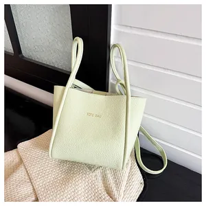 Detail der mintgrünen Leder-Einkaufstasche mit Litschi-Muster und goldenem TOTE BAG-Schriftzug