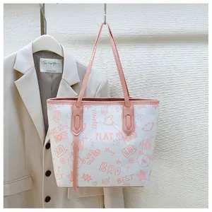 Detail of a large capacity tote bag with pink graffiti patterns and long shoulder straps