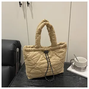 Detail view of khaki quilted tote bag featuring heart pattern embroidery and drawstring