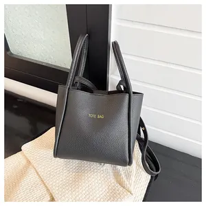 Detail der schwarzen Tote Bag mit Lychee-Muster, Gold-Schriftzug und verstellbarem Riemen