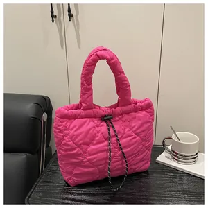Detail of rose red heart-quilted puffer bag featuring drawstring and padded handles