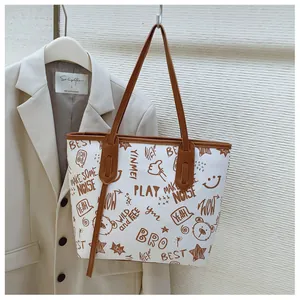 Macro detail of graffiti print and brown shoulder straps on white canvas tote bag