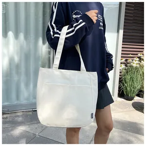 Detailopname van witte canvas shopper met voorvak en een stevige stoffen textuur