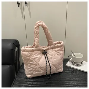 Detail of light pink quilted tote bag with heart patterns and drawstring closure