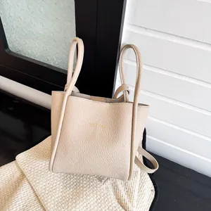 Elegante beige Tragetasche aus genarbtem Leder mit Griffen und TOTE BAG Aufdruck vorne