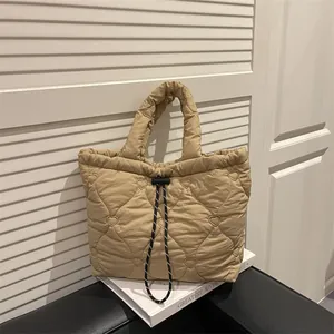 Khaki quilted dumpling tote bag featuring heart embroidery and drawstring closure