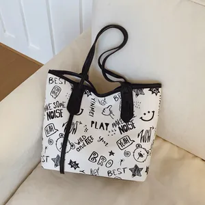 Large capacity graffiti print tote bag with black shoulder strap on white faux leather