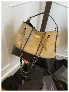 Detail of color-block tote bag with classic diamond stitching and golden turn-lock closure