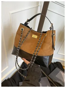 Detail of color-block bucket bag with quilted suede and chain shoulder strap