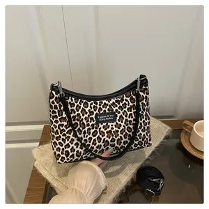 Dettaglio borsa shopper leopardata con etichetta logo nera e tracolle regolabili staccabili