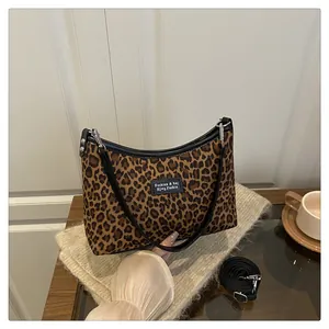 Dettaglio della borsa tote leopardata con finiture in pelle nera e tracolla regolabile