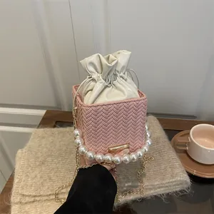 Pink woven bucket bag with pearl handle and drawstring closure for women
