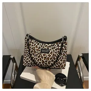 Dettaglio della borsa tote leopardata con finiture in pelle nera e tracolla regolabile
