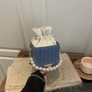 Blue herringbone bucket bag with pearl handle and metal chain for chic winter style