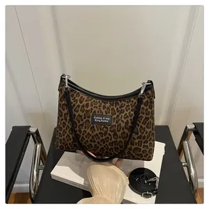 Dettaglio della borsa tote leopardata con bordo nero e tracolla nera rimovibile