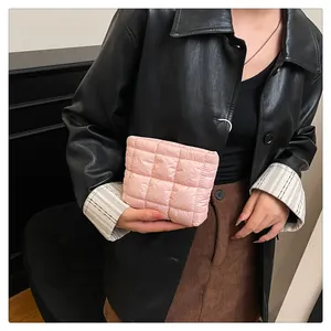 Nahaufnahme der rosa gesteppten Stofftextur und Nähte an einer kompakten Handtasche
