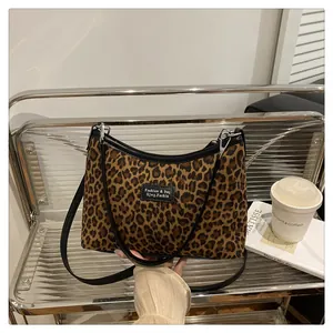 Dettaglio della borsa tote leopardata con bordo nero e cerniera in metallo