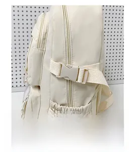 Dettaglio della fibbia di qualità e tasca laterale di uno zaino in nylon bianco crema