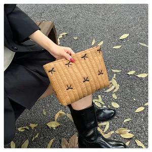 Nahaufnahme der braunen Stepp-Clutch mit schwarzen Schleifenstickereien aus Nylon